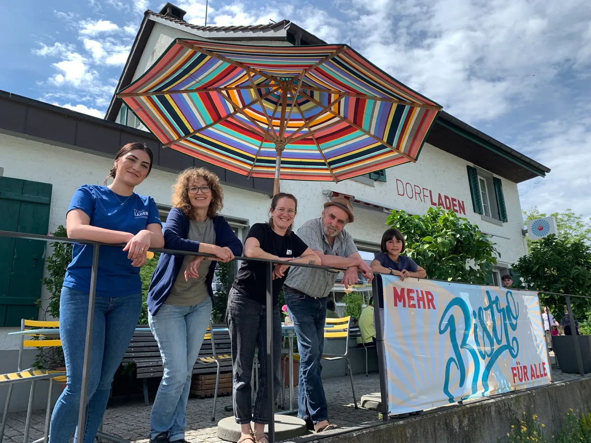Dorfladen Seegräben am 13. Mai 2024 mit der Stiftin Aleyna Adiyamanlier (im Shirt Dorladen), Andreas Ott, Präsident Verein Dorladen (mit Hut), Liegenschaftenbesitzerin Eva Raths (offenes Haar) und Katja Horlacher, Betriebsleiterin Dorladen ( schwarzes T-Shirt), dazu Blick in die Brotauslage, Kasse Ladenbistro, Gemüse, Terrasse, Eingang