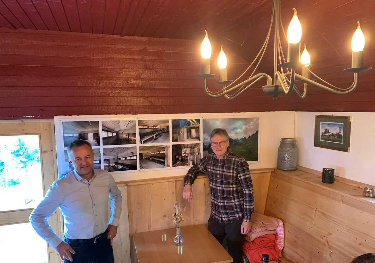 Martin Vögeli (links) und Hubi Rüegg von der Genossenschaft Bachtel-Kulm stehen vor einigen Fotos, die an der Wand hängen. 