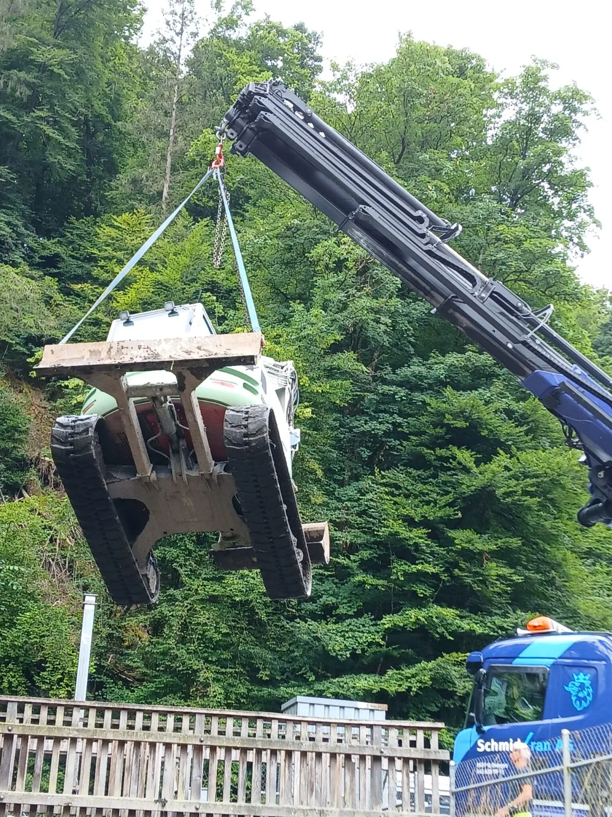 Ein Kran hievt einen Bagger in den Fabrikkanal. 