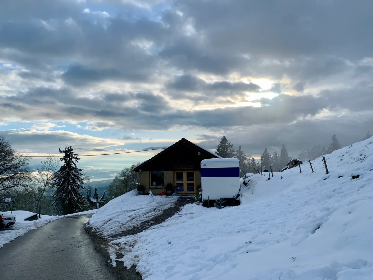 Blick auf ein Gebäude, vor dem ein Wagen steht.