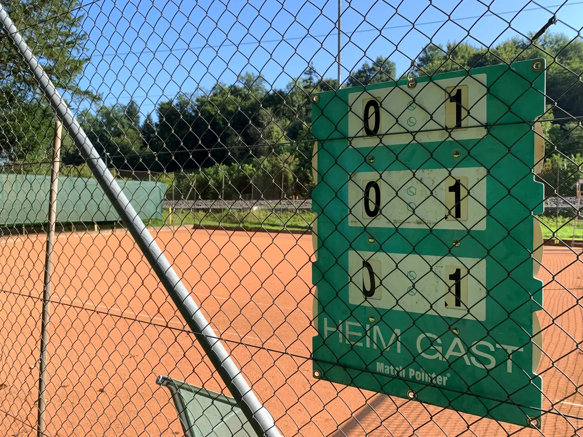 Tennisplatz mit Anzeigetafel  beim Trümplerareal in Oberuster neben dem Gleis.