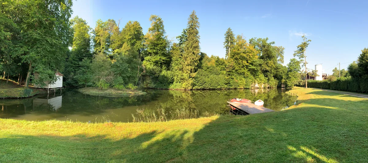 Weiher mit Pedalo und Badehäuschen des Trümpler-Parks beim Trümplerareal in Oberuster.