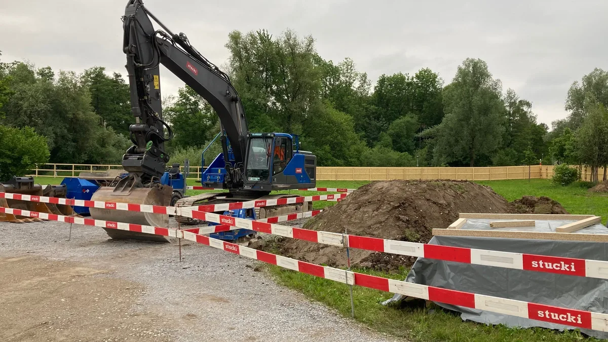 Ein Bagger auf einer Wiese.