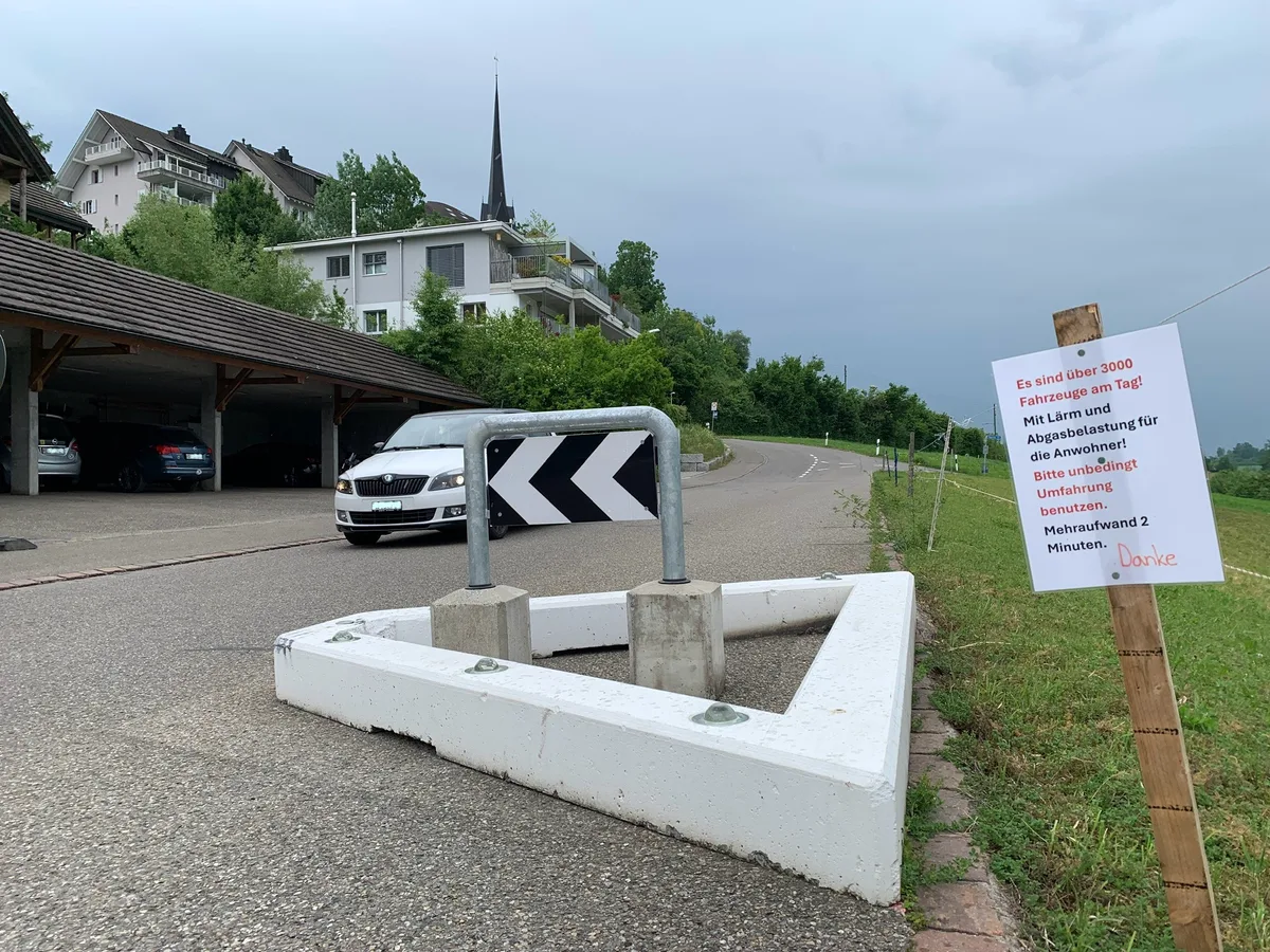 Mit Schildern machen Anwohner der Haldenstrasse auf den dichten Ausweichverkehr aufmerksam. Ein Schild und ein Strassendreieck an der Haldenstrasse in Gossau.