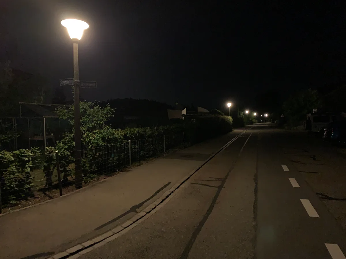 Eine dunkle Strasse mit einigen alten Strassenlaternen.