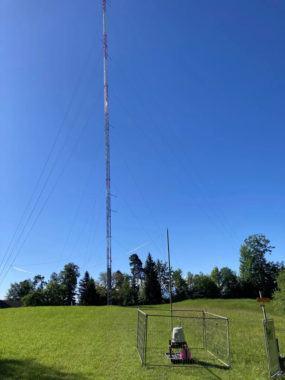 Ein Messgerät steht vor einem hohen Mast auf dem Batzberg. 