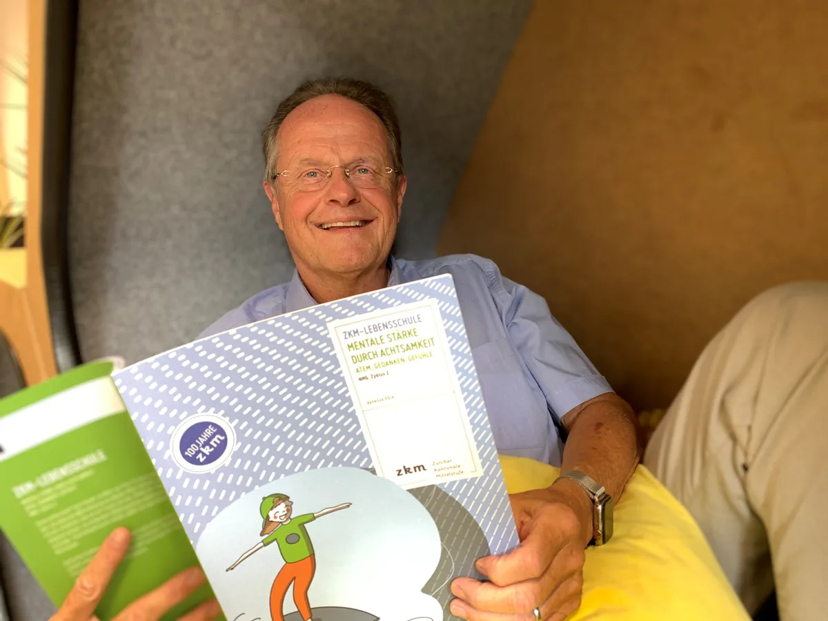 In der Liegewabe in der neuen «Schulinsel» des Mettlen-Schulhauses kann es sich auch Christoph Hämmig gemütlich machen. Christoph Hämmig, Verlagsleiter ZKM, liegt in einer Wabe und hält ein Buch in der Hand.
