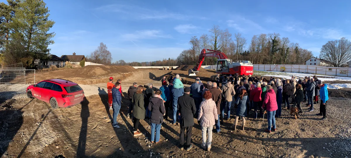 Eine grosse Gruppe von Leuten steht auf einer Baustelle.