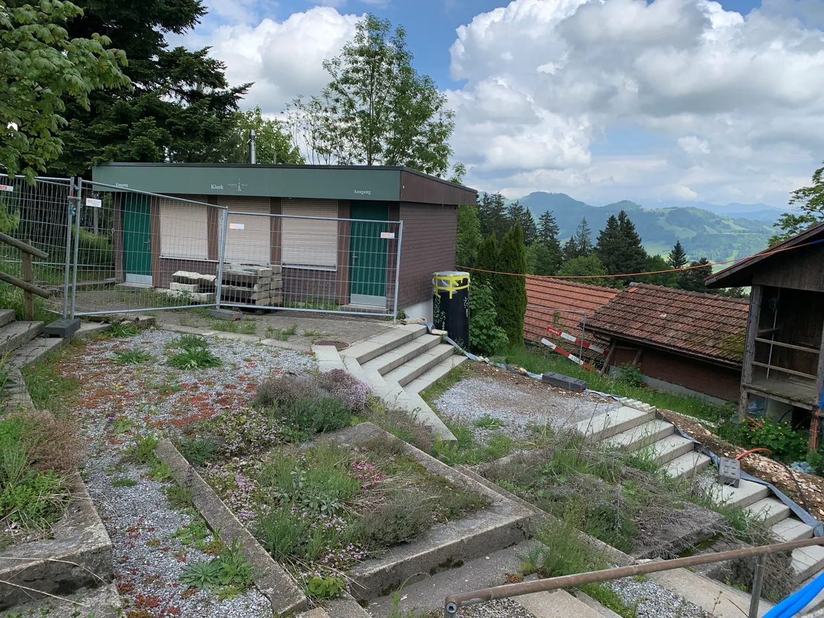 Beete, Treppen und mehrere Gebäude.