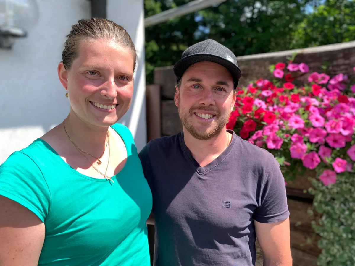 Monika und Manuel Schuler stehen vor einem aufgehängten Blumenkistchen.