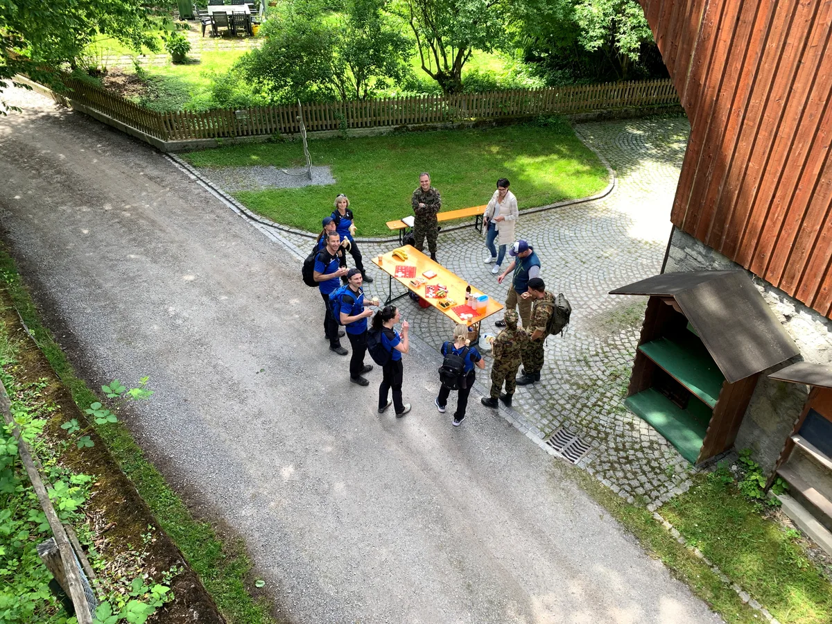 Leute stehen um einen Tisch im Freien.