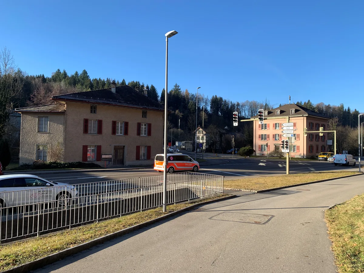 Zwei Häuser an der Kreuzung Zürich-/Gstalderstrasse mitten in Aathal, im Hintergrund der ehemalige Bahnhof Aathal.