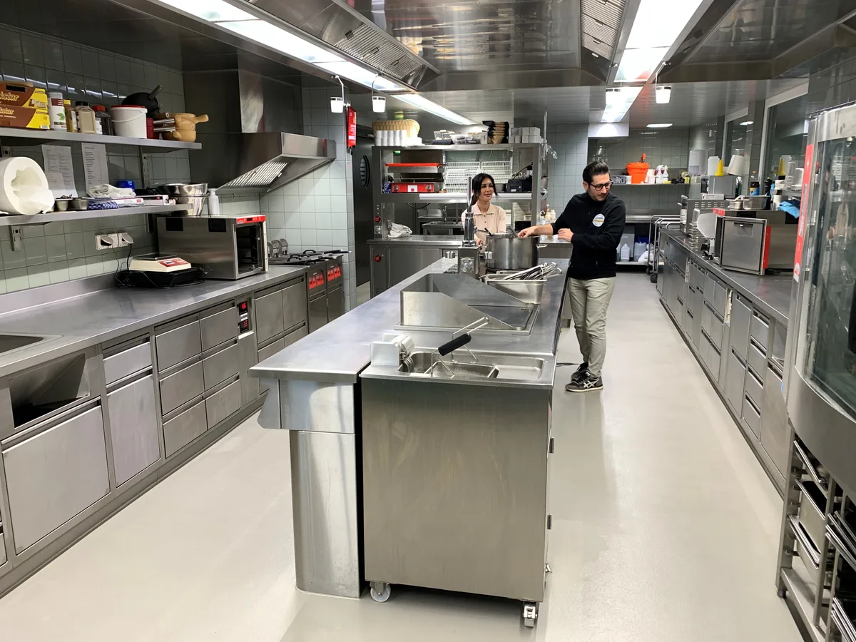 Von der neuen, grosszügig gestalteten Küche im Restaurant Bachtel-Kulm sind Ayse Baskapan (links) und Sahin Albas begeistert. Ayse Baskapan und Sahin Albas stehen in einer grossen Restaurantküche.