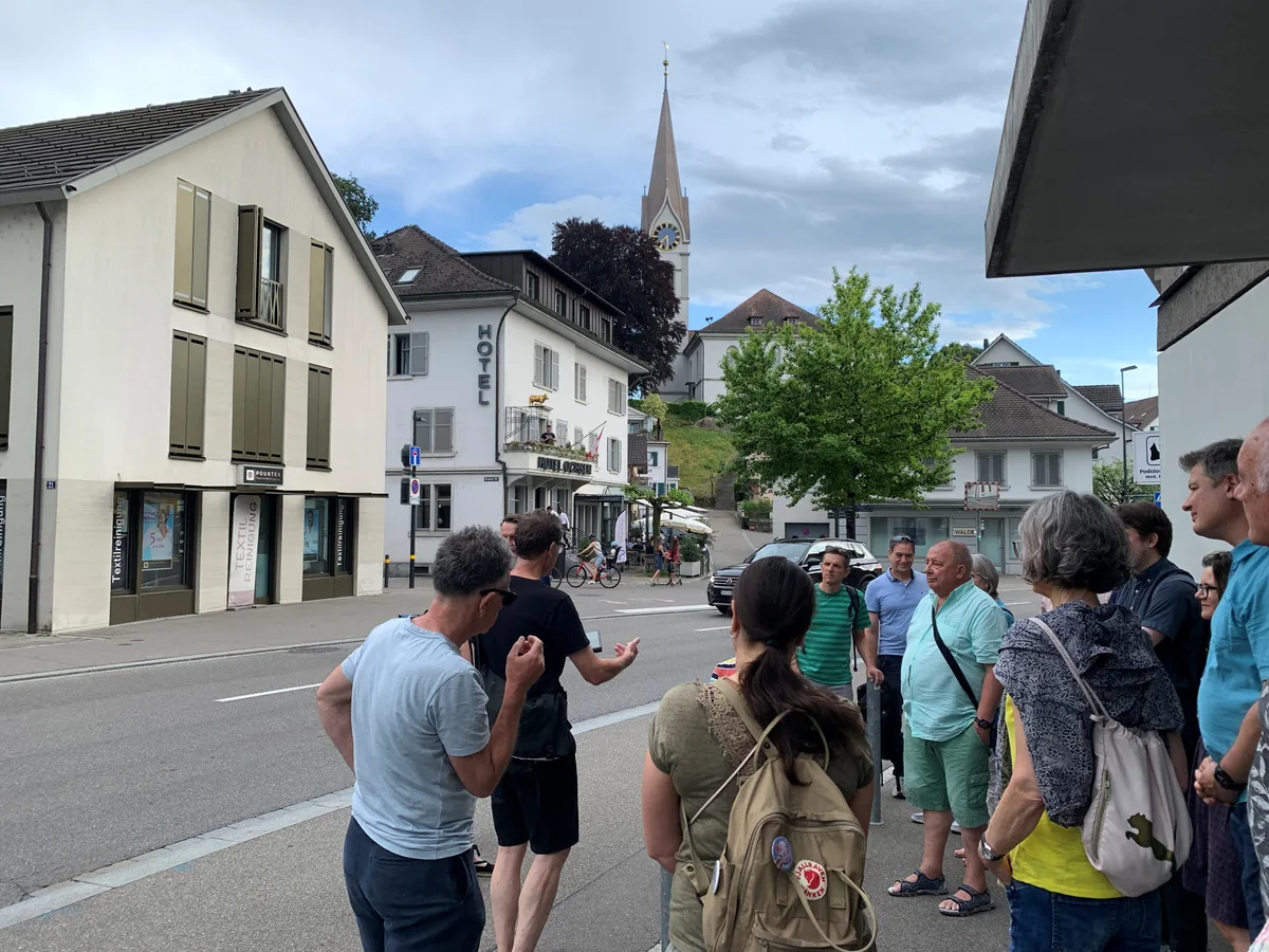 Leute stehen an der Zentralstrasse in Uster, im Hintergrund die reformierte Kirche.