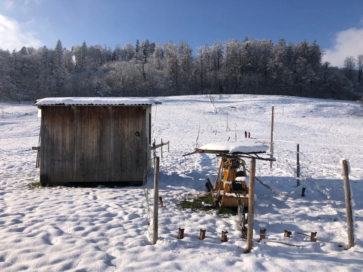 Ein sehr kleiner Skilift in einer verschneiten Landschaft.
