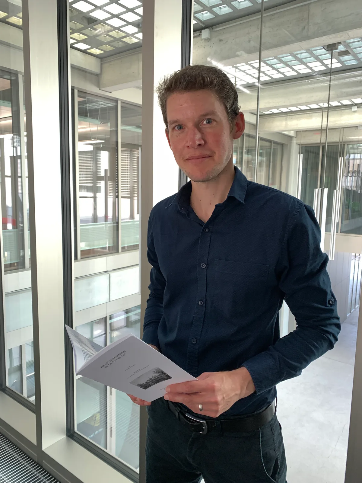 Lukas Leuzinger hält eine Broschüre zum Ustertag in den Händen.