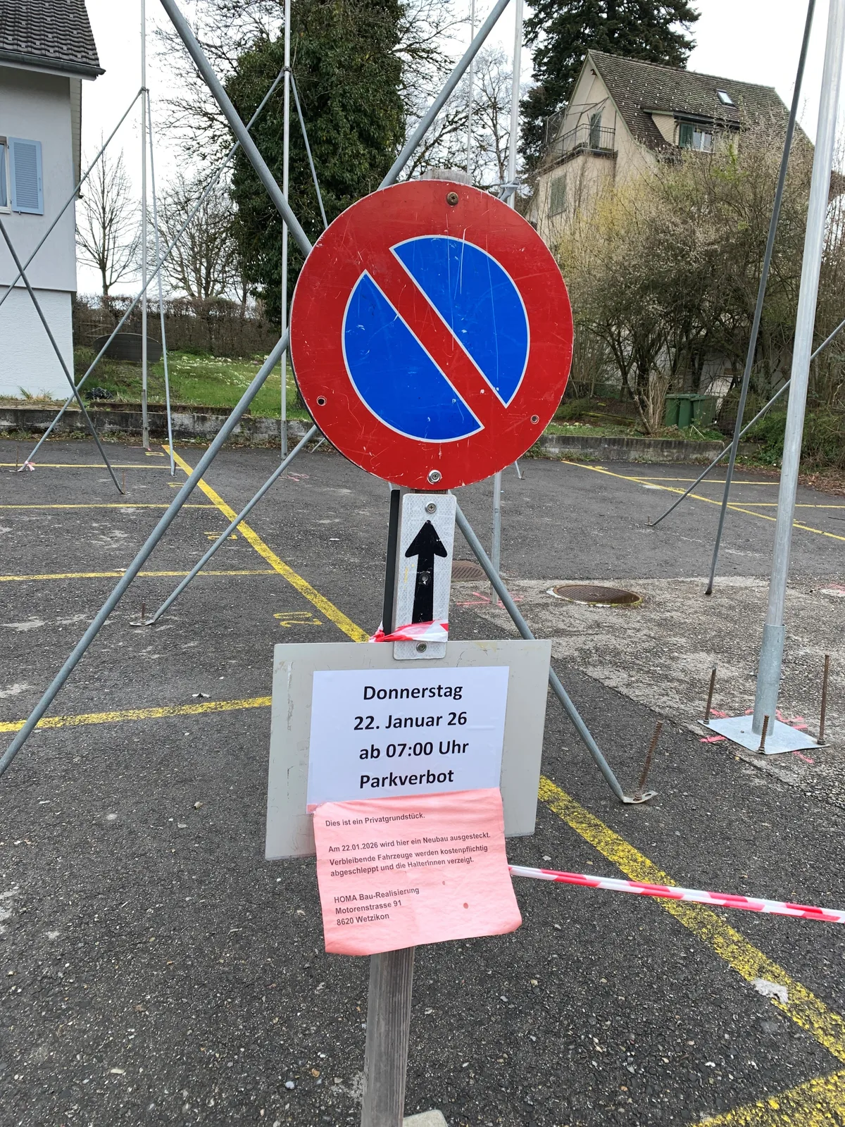 Auf einem Parkplatz stehen Baugespanne und eine Parkverbotstafel. 