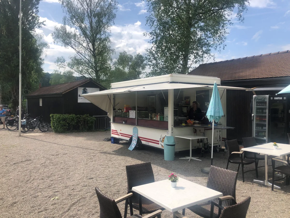 Ein mobiler Essstand steht vor einer Baracke.