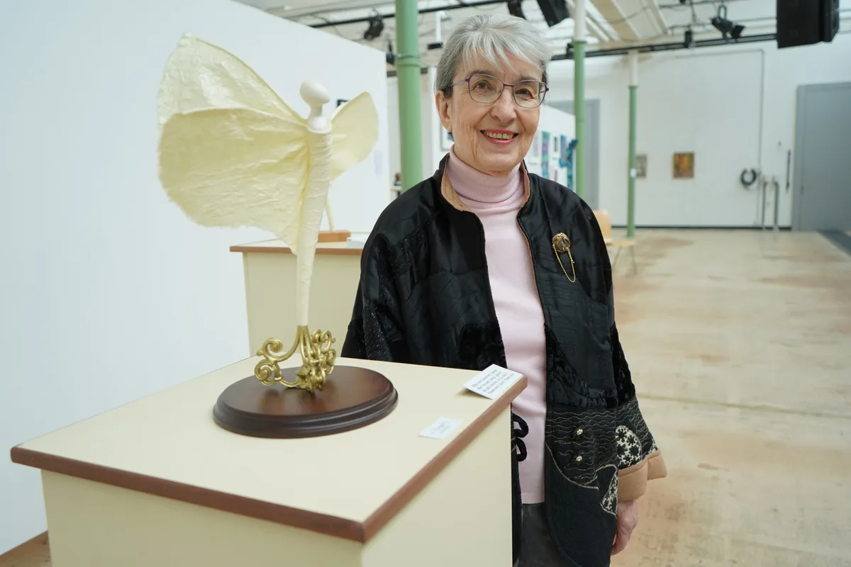 Eine Frau neben einer Skulptur.