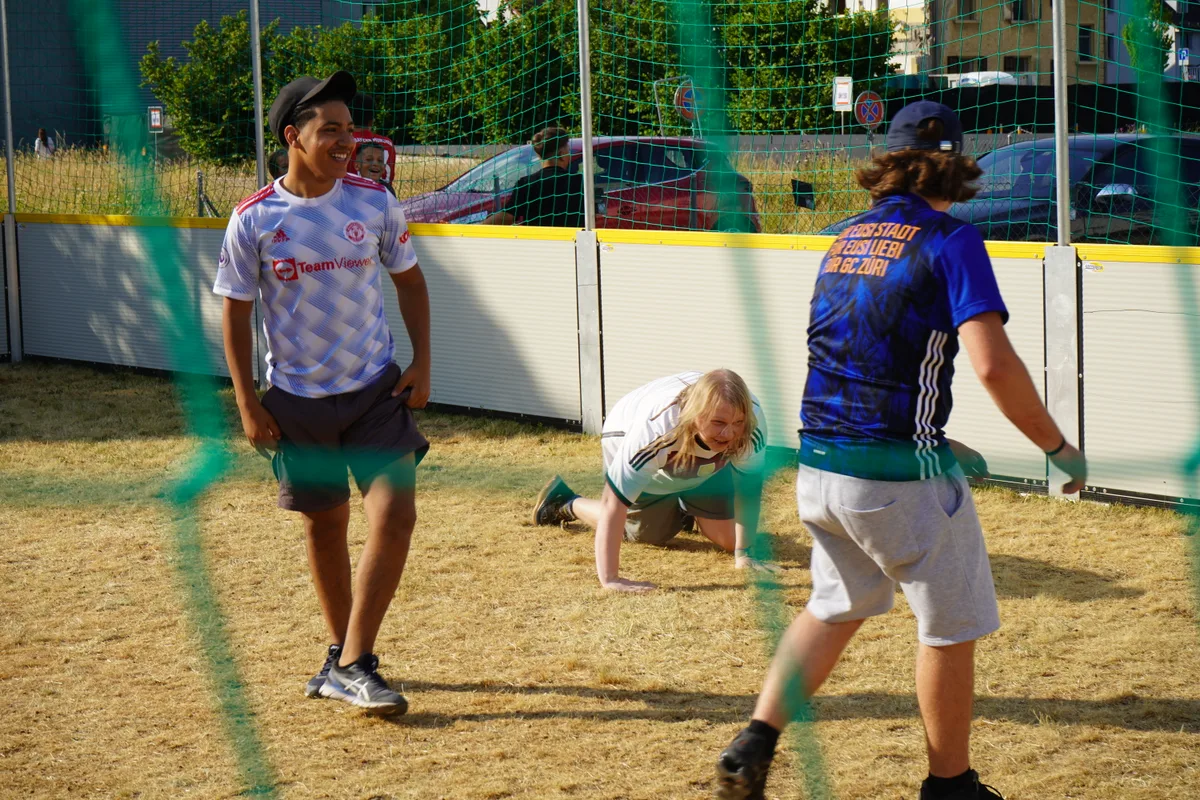 Ein Mann kniet auf dem Boden eines Fussballplatzes.