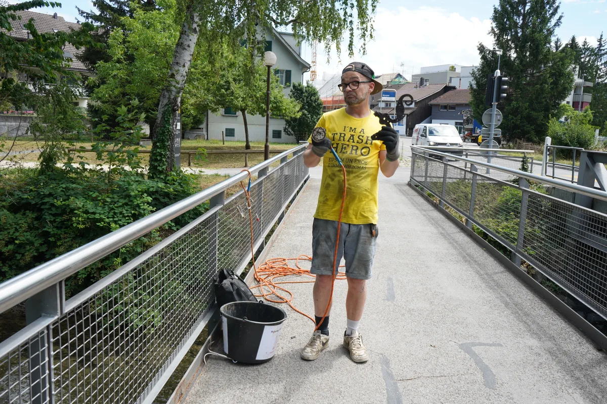 Marcus Sonnenberg fischt mit einem Magneten Metall aus der Glatt.