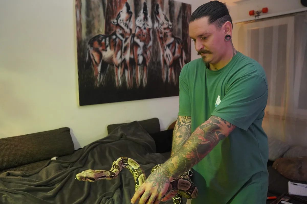 Ein Mann mit einer Schlange in der Hand.