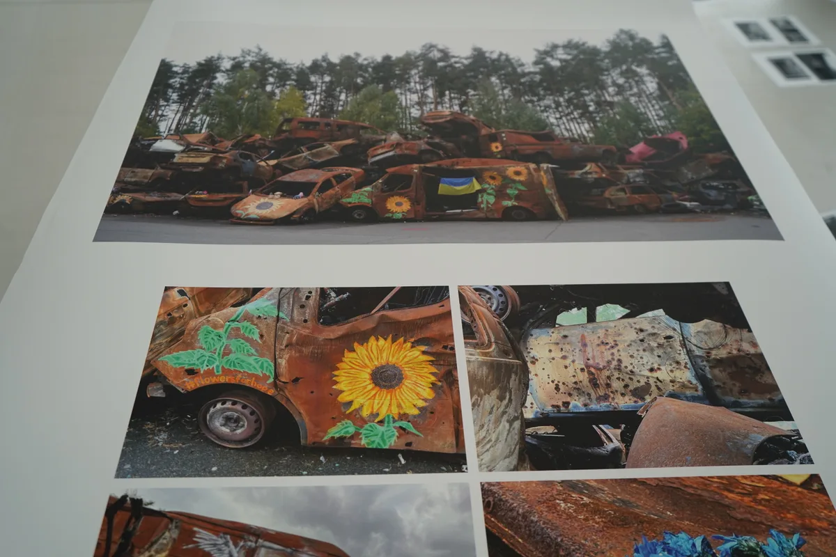 Auf den rostigen Autos sind Sonnenblumen aufgemalt.
