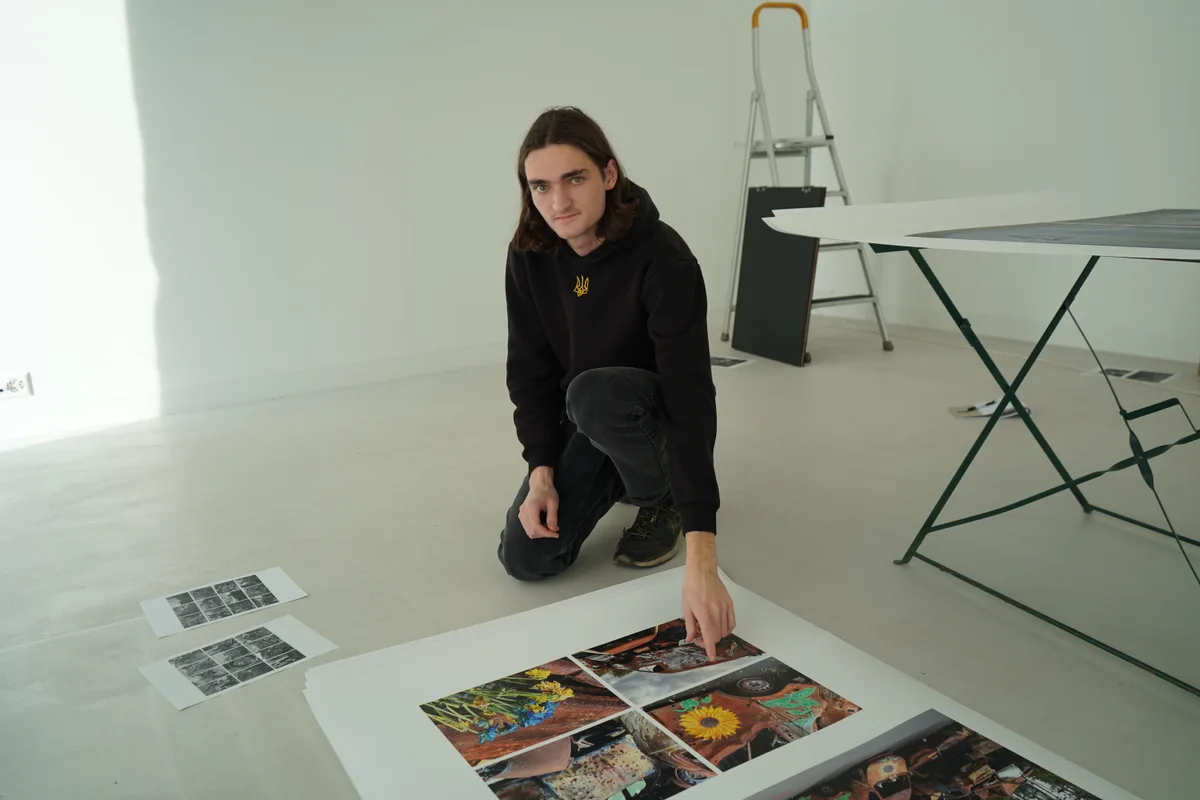 Gian Walder zeigt auf ein Plakat der Ausstellung.