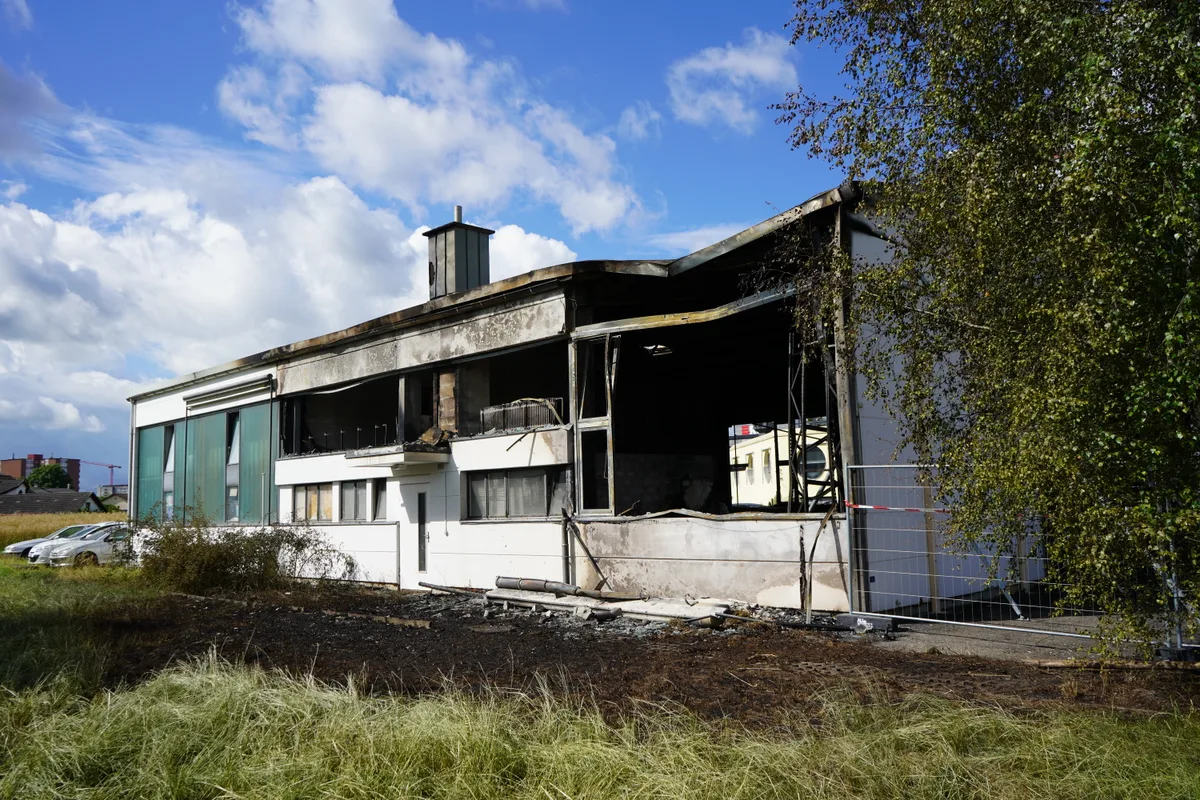 Ausgebrannte Autogarage. ein verbrannter Food Truck und verbrannte Autos in einer Autowerkstatt.