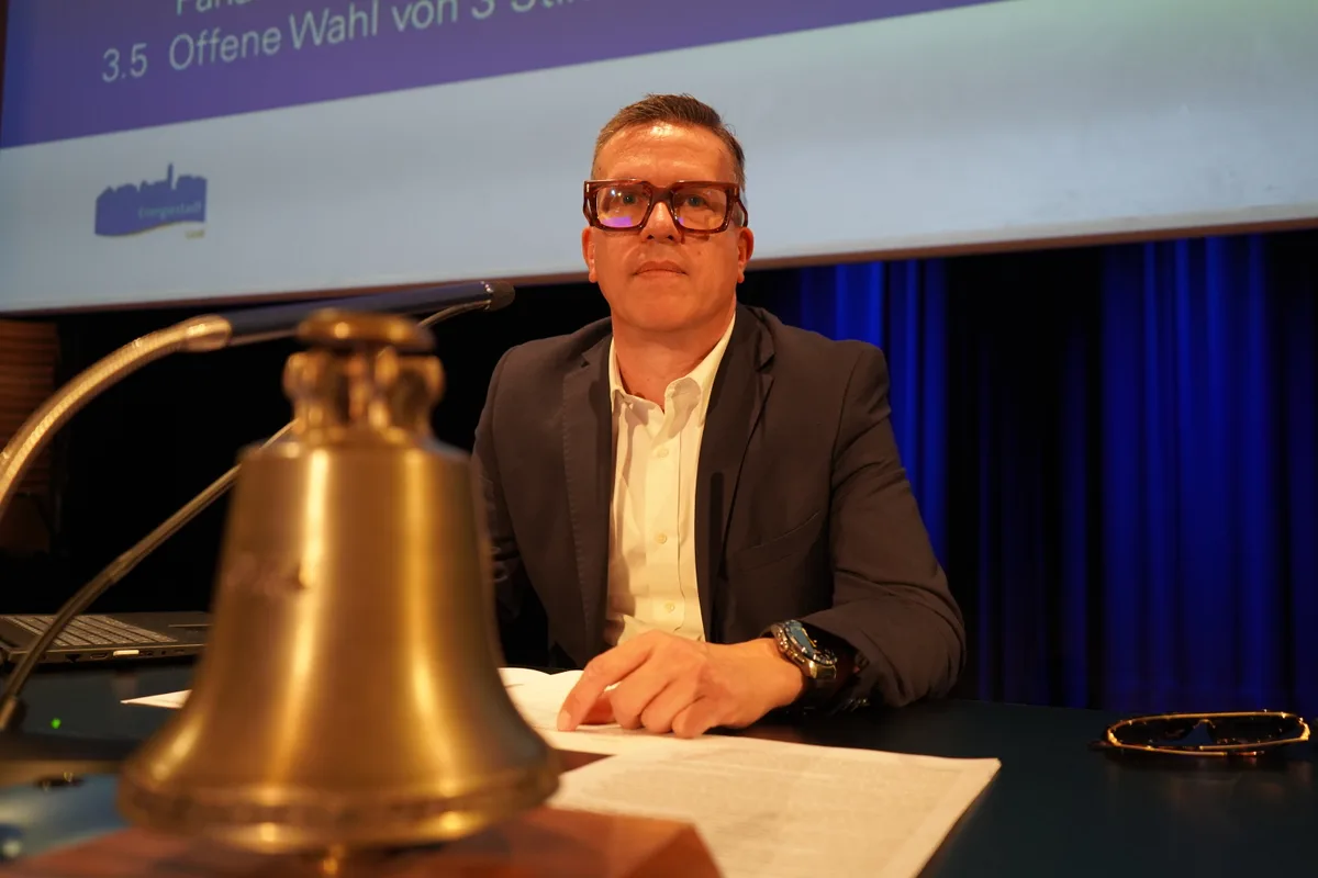 Ein Mann sitzt hinter einer Glocke.