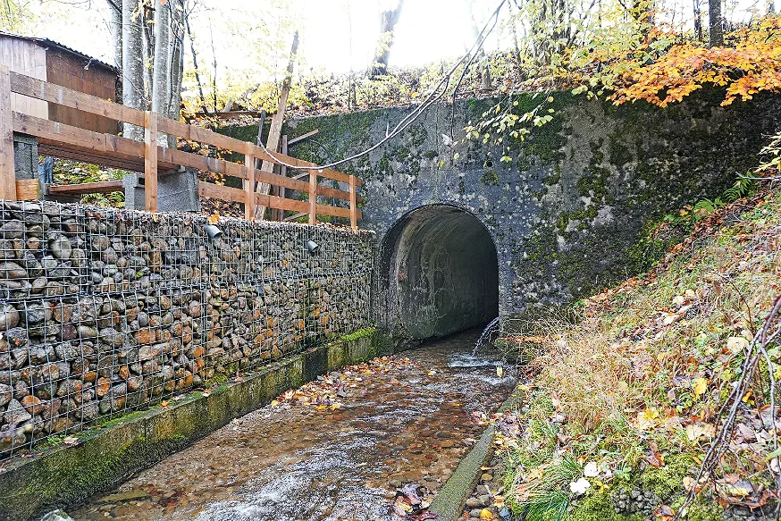 Ein Bach, der in einen Tunnel fliesst.