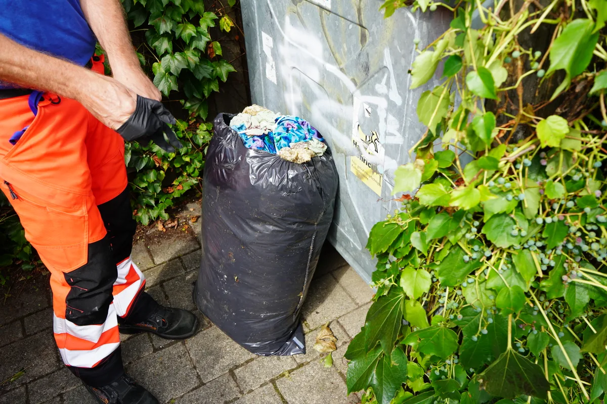 Ein Mann mit einem Abfallsack in der Hand.