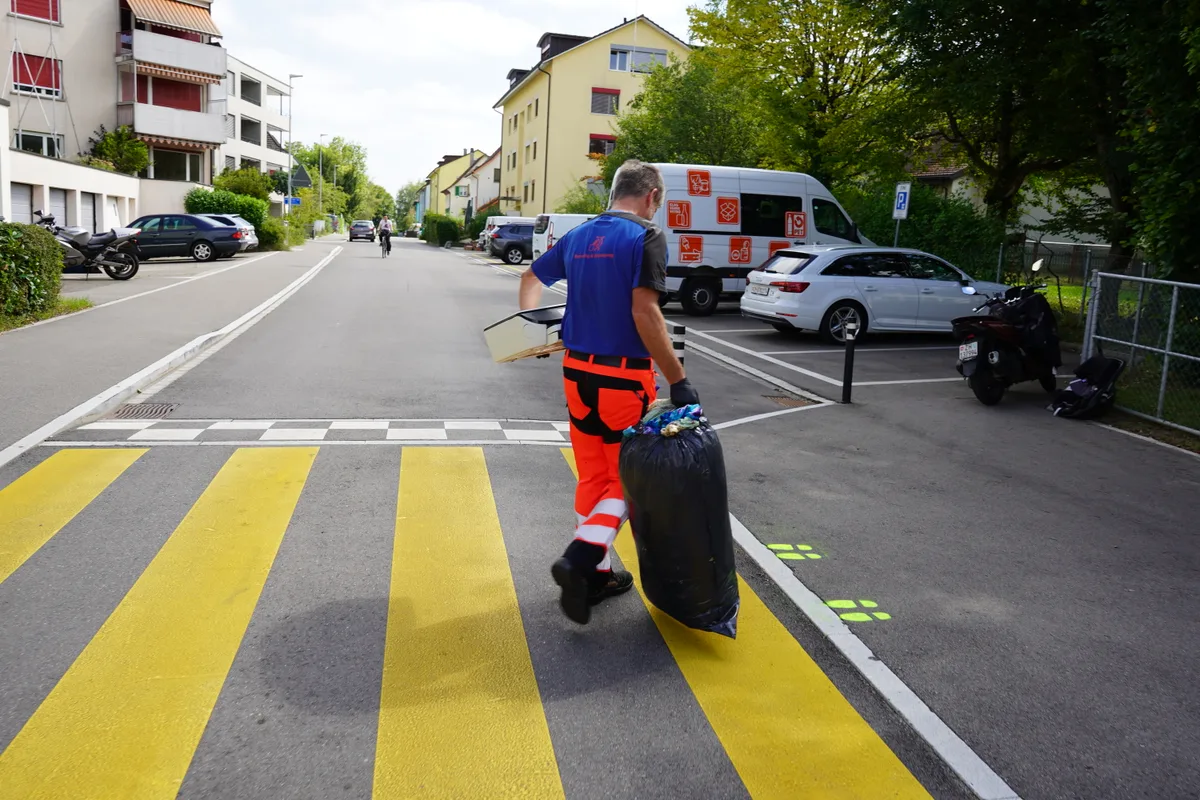 Ein Mann mit einem Abfallsack in der Hand.