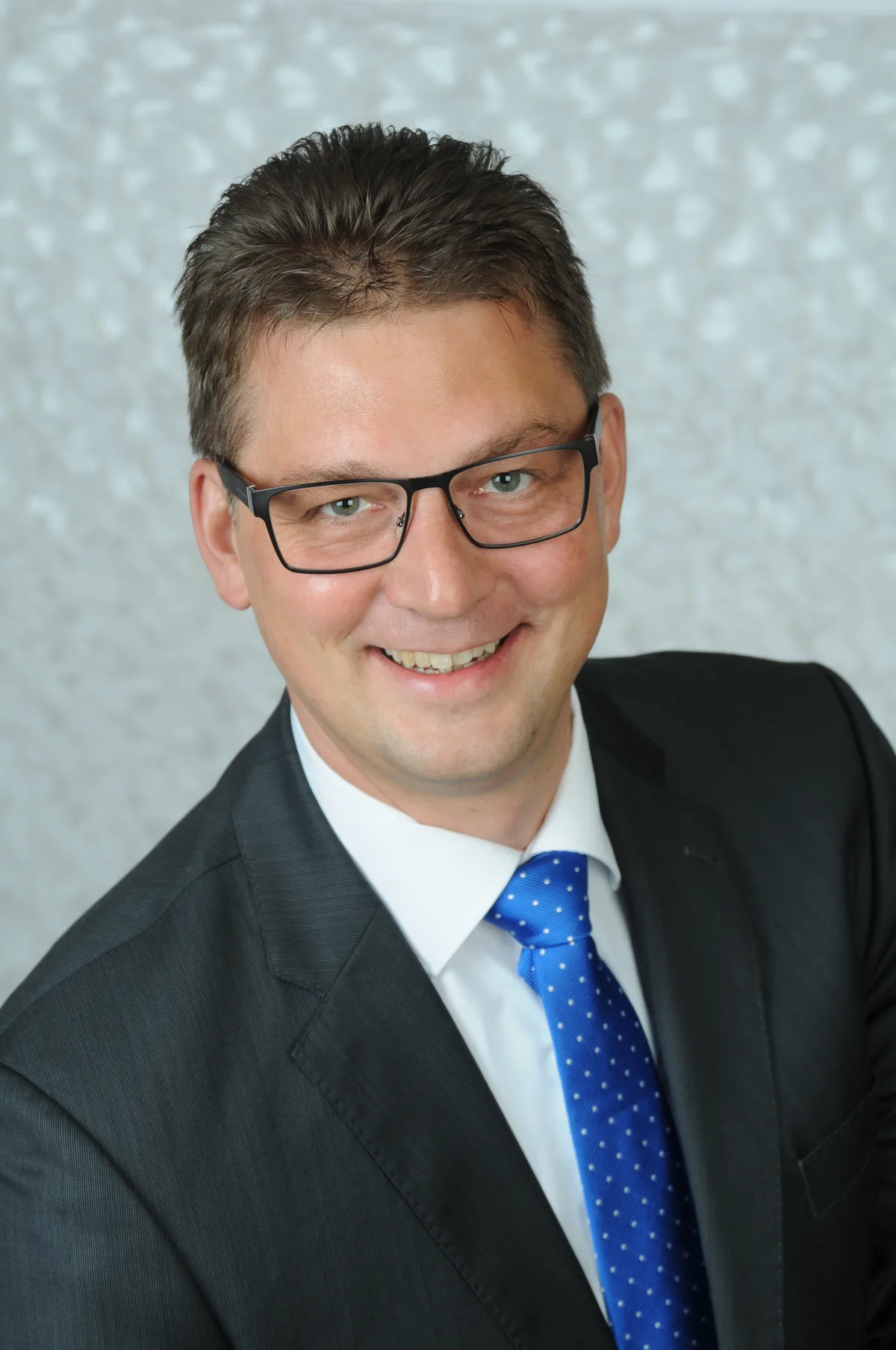 Ein Herr im Anzug und mit blauer Krawatte.