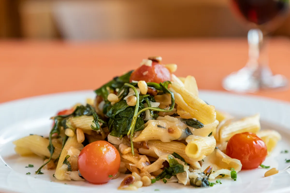 Pasta mit Pinienkernen garniert.