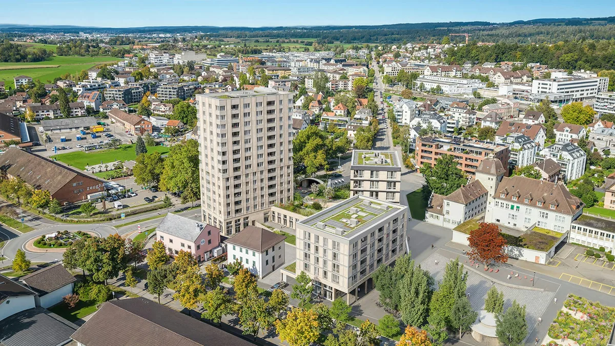 Die Visualisierung zeigt die neue Überbauung Gerichtsplatz, wie sie sich ab diesem Sommer nach Abschluss der Umgebungsarbeiten präsentieren soll. Drei grosse Wohnblöcke stehen inmitten von niedrigeren Bauten.