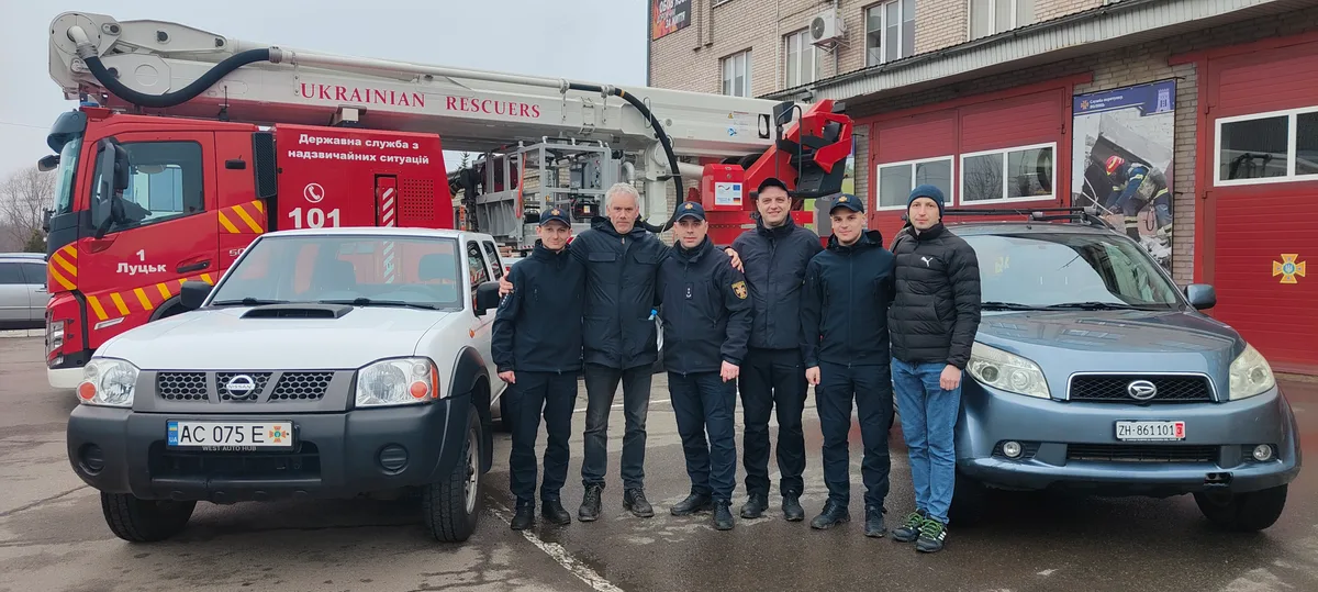 Menschen vor diversen Fahrzeugen.
