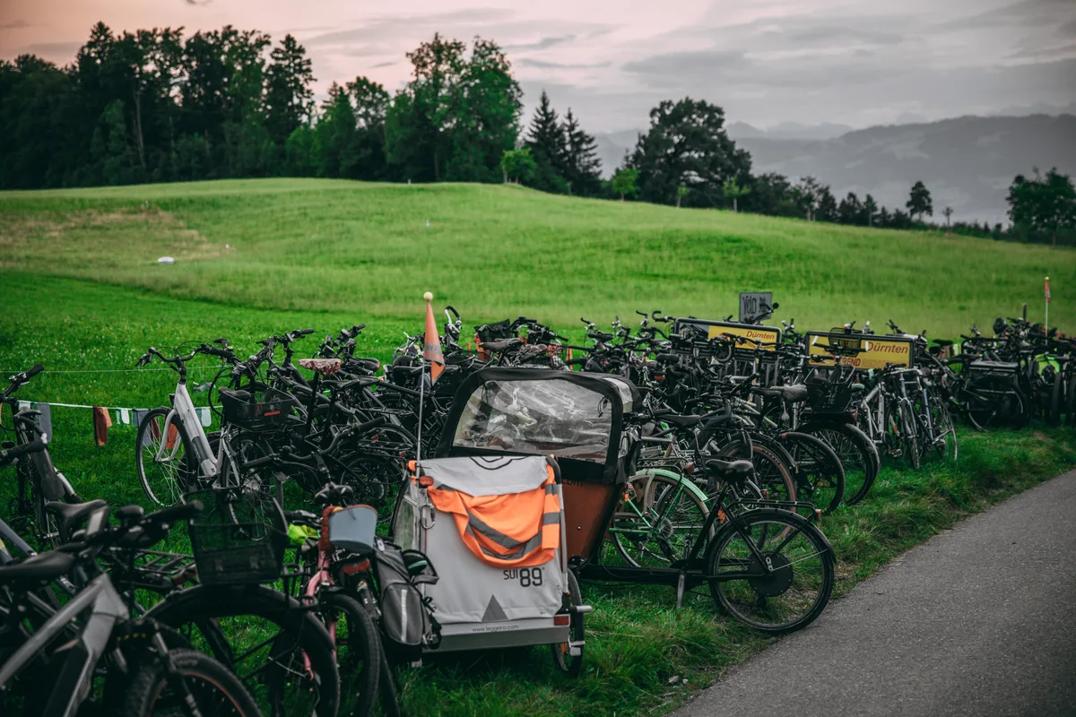 Viele abgestellte Fahrräder auf einer Wiese.