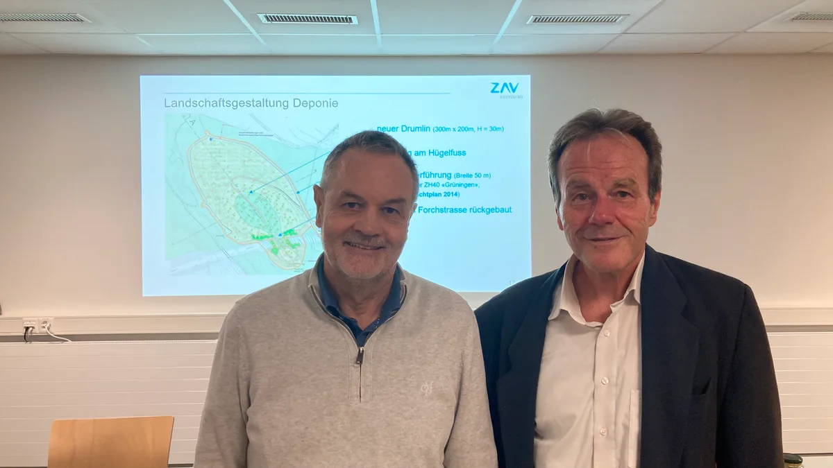 Zwei Männer stehen vor einer Präsentation.