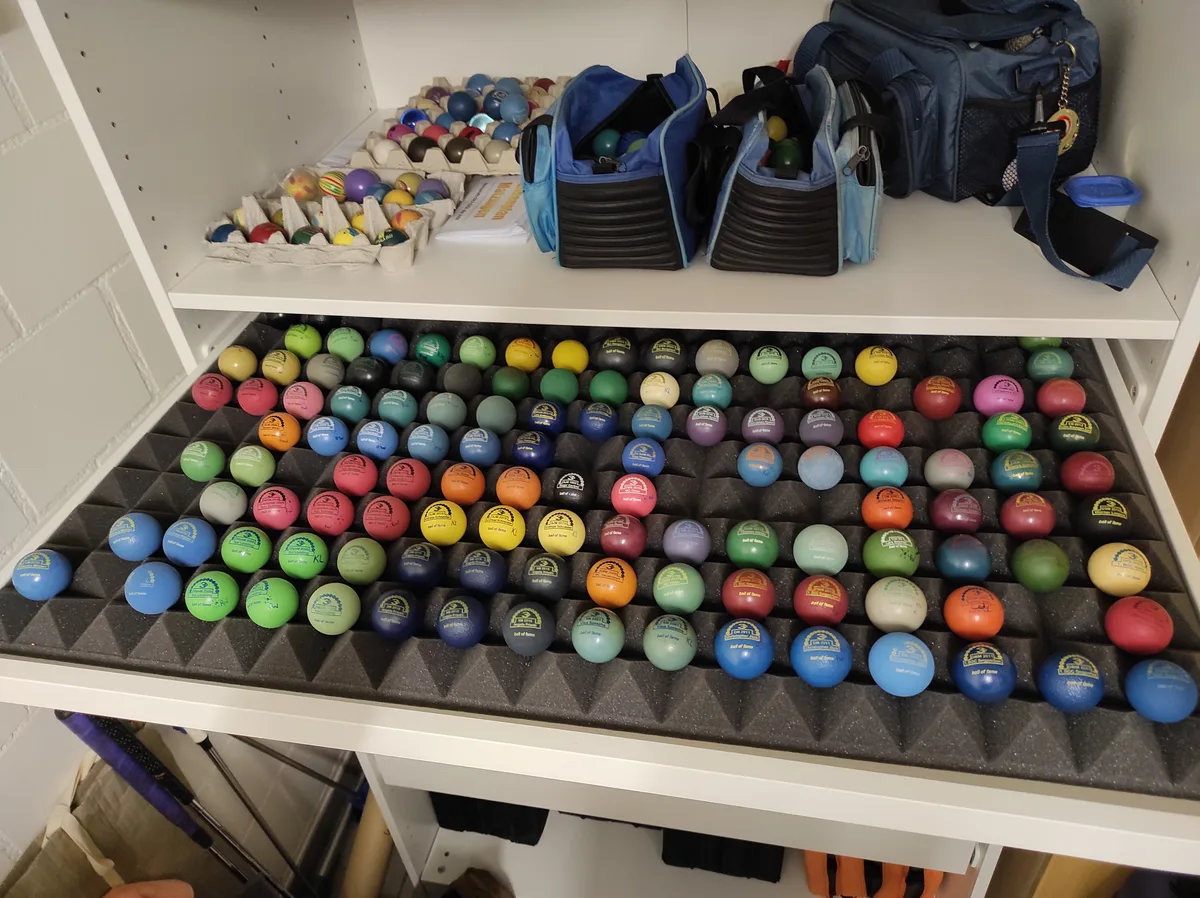 Eine Schublade voll mit farbigen Minigolfbällen.