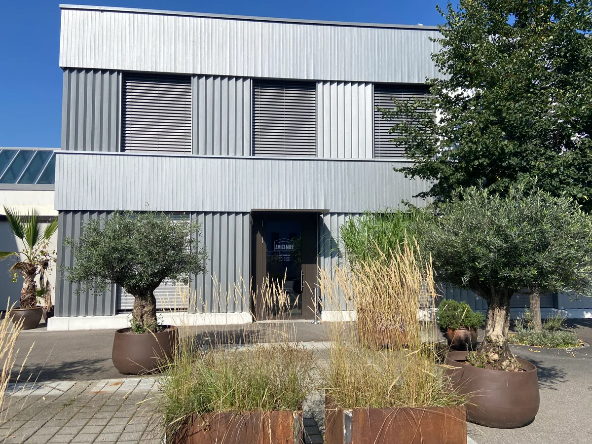 Ein Ladenlokal von aussen. Davor stehen Pflanzen.