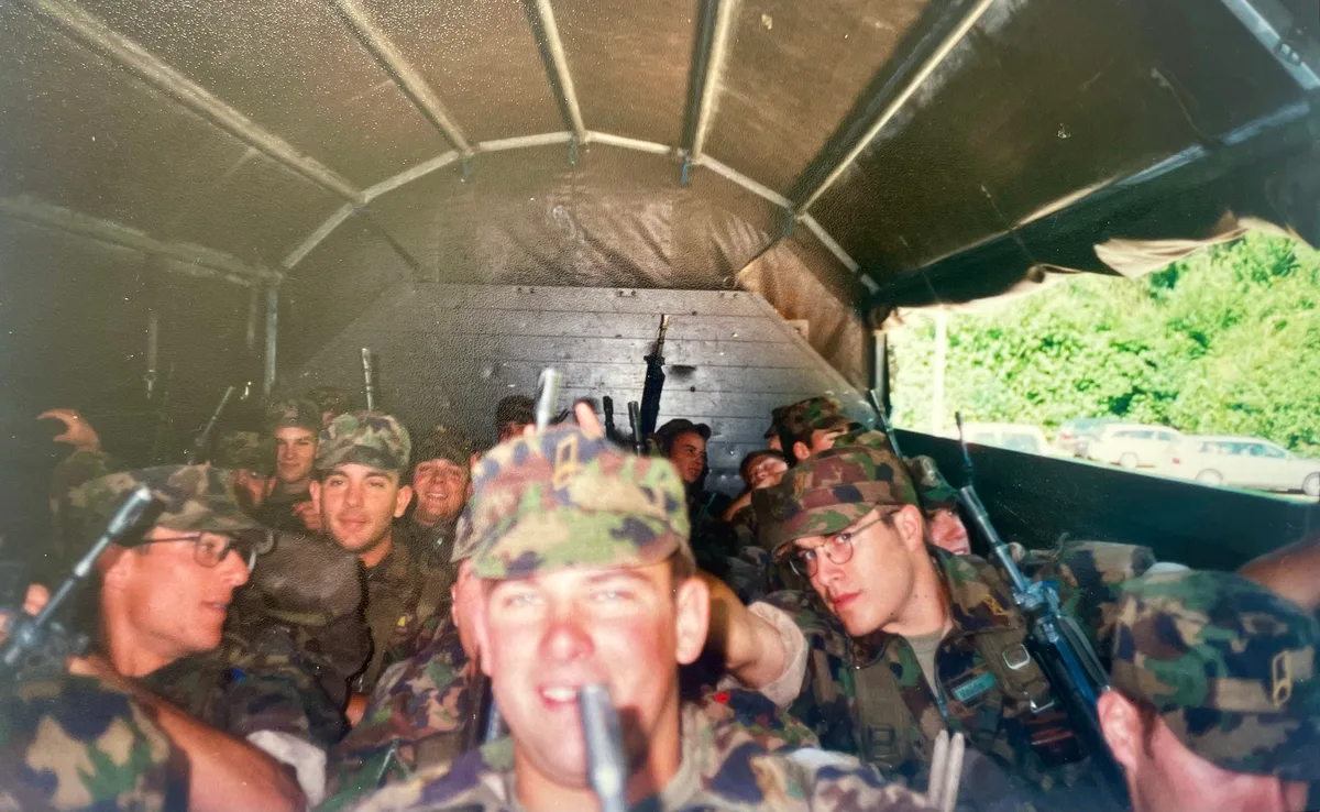 Noch sind alle frohen Mutes: Die Offiziersaspiranten werden im Juli 2000 per Lastwagen zum Startpunkt des 100-Kilometer-Marschs auf den Üetliberg gefahren. Im Vordergrund sitzt der Gossauer Daniel Wäfler, links mit Brille der Initiant des jetzigen Militärmarschs, Martin Geiser. Offiziersaspiranten sitzen in einem Lastwagen.