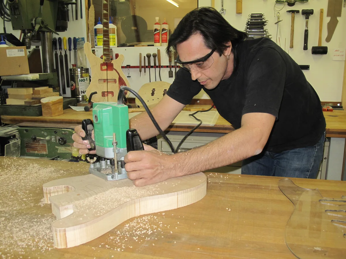 Andy Margharitis sägt eine Gitarre aus Holz.