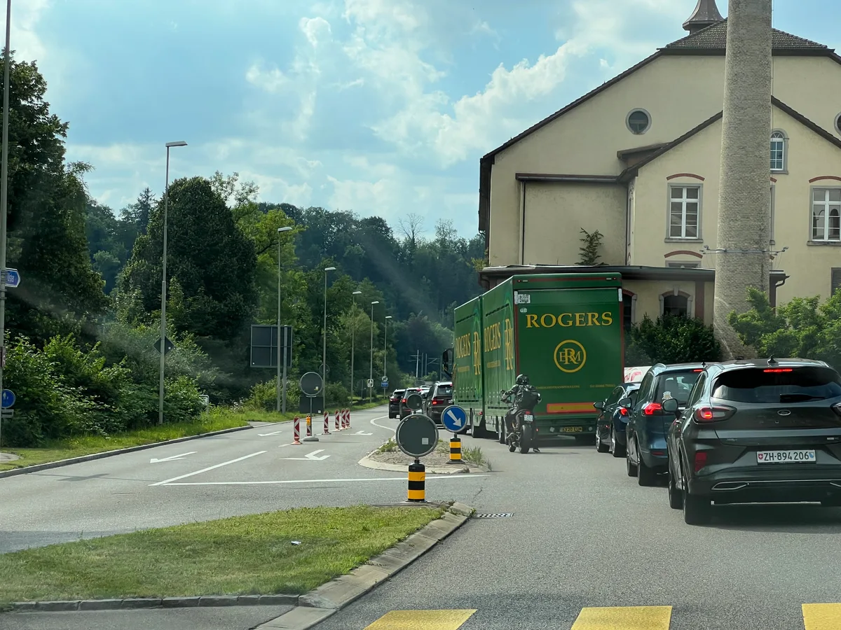 Mehrere Fahrzeuge stehen auf einer Strasse im Stau..