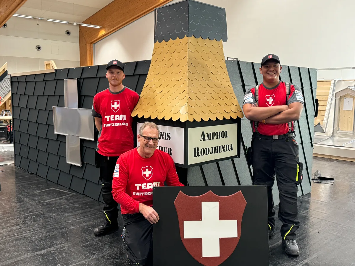 Zwei Dachdecker stehen neben einem goldenen Dach.