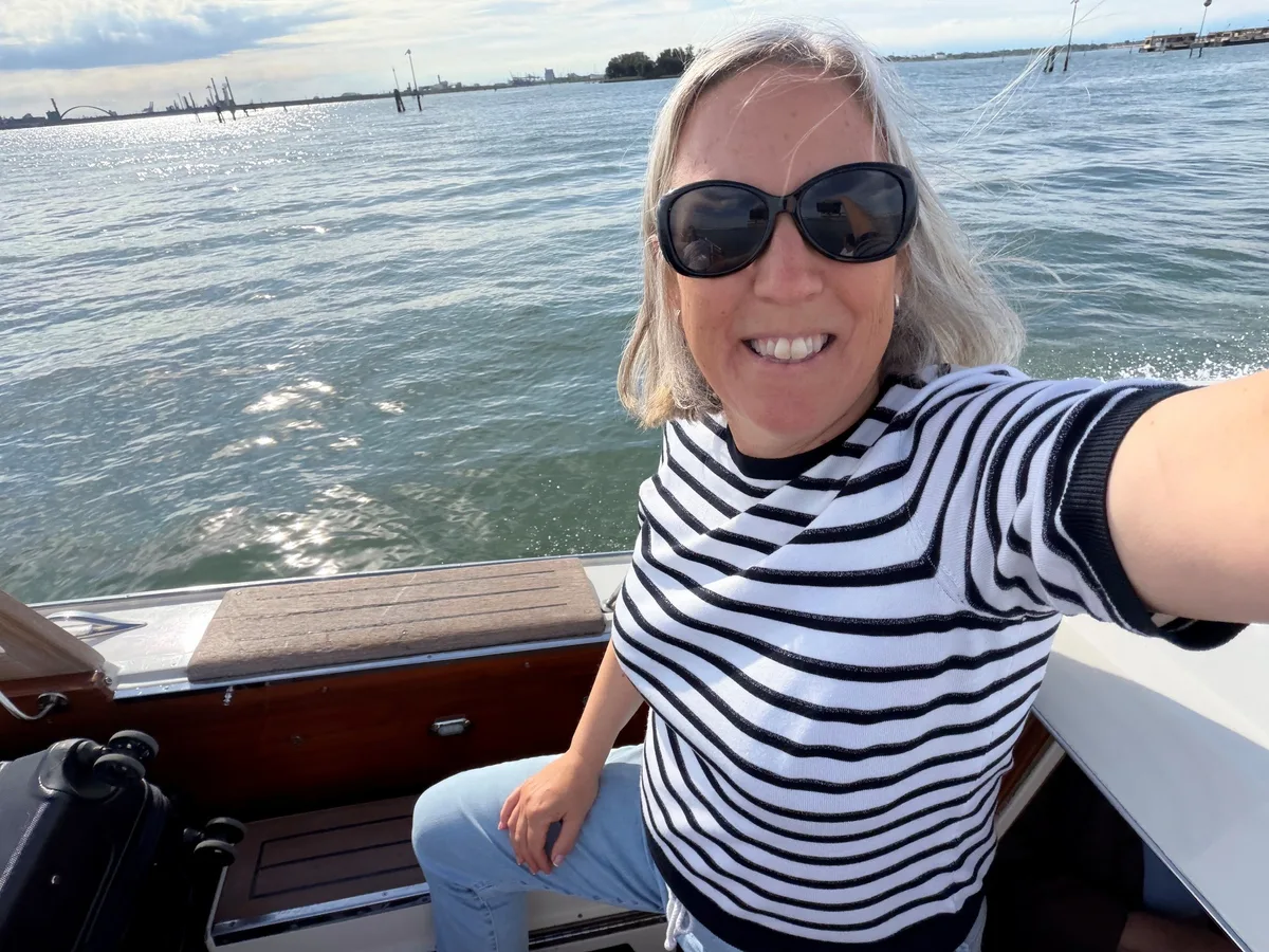 Auch unsere Redaktorin und Reisebegleiterin Bea Zogg hatte sichtlich Spass an der Überfahrt zum Markusplatz in Venedig. Selfie von ZO-Redaktorin Bea Zogg. Sie trägt ein gestreiftes Shirt und eine Sonnenbrille. Im Hintergrund Wasser.