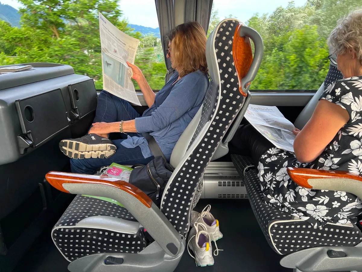 Der ZO wird fleissig im Car gelesen. Zwei Frauen sitzen in einem Reisecar und lesen den Zürcher Oberländer.