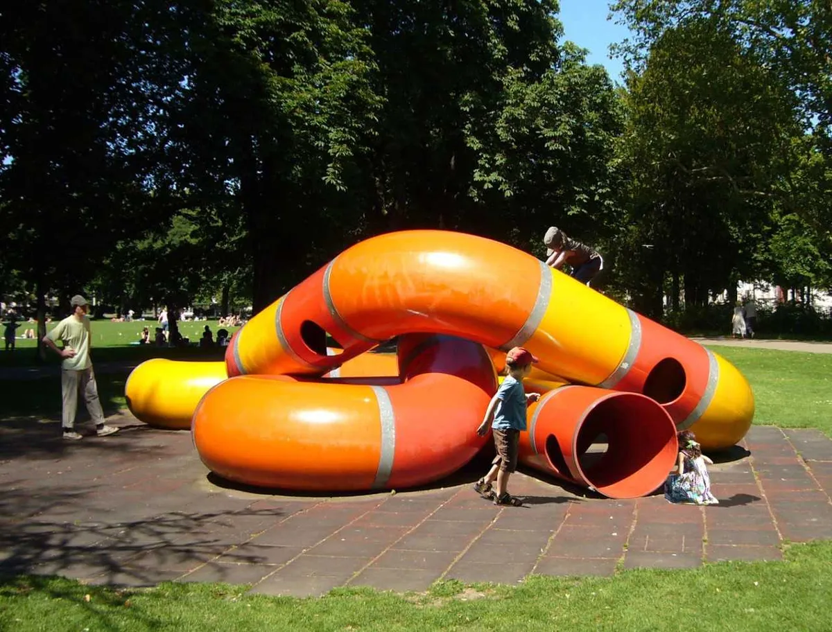 Man sieht einen Spielplatz mit dem «Lozziwurm» und spielenden Kindern.