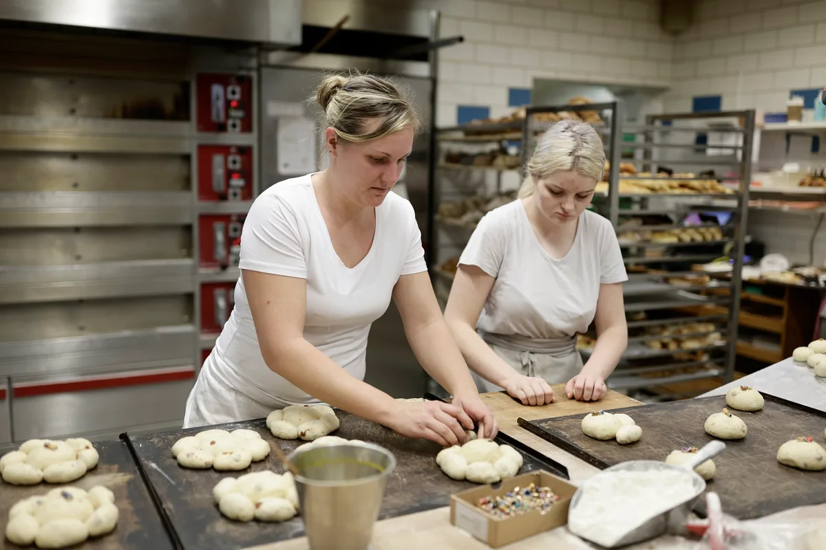 Die Herstellung der Dreikönigskuchen verlangt Konzentration: Lotti Honegger (links) und Lehrtochter Kim Hauri. In der Oetwiler Vollkornbäckerei Scharrenberg werden Dreikönigskuchen gebacken, mit einem handgefertigten König aus Ton.