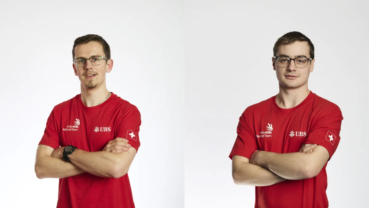 Zwei Männer stehen mit verschränkten Armen da.